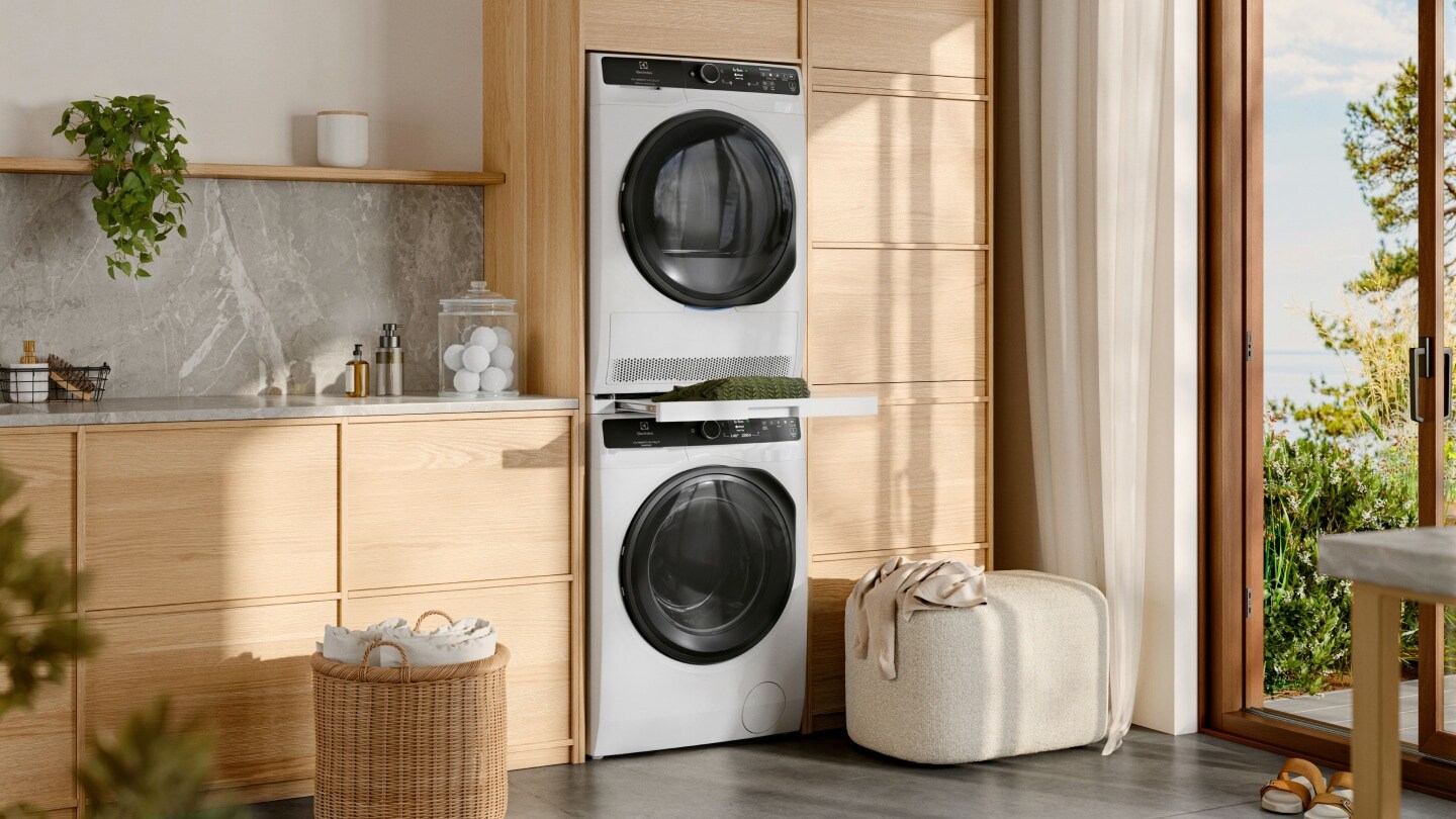 A washing machine and tumble dryer from Electrolux, stacked in a laundry room.