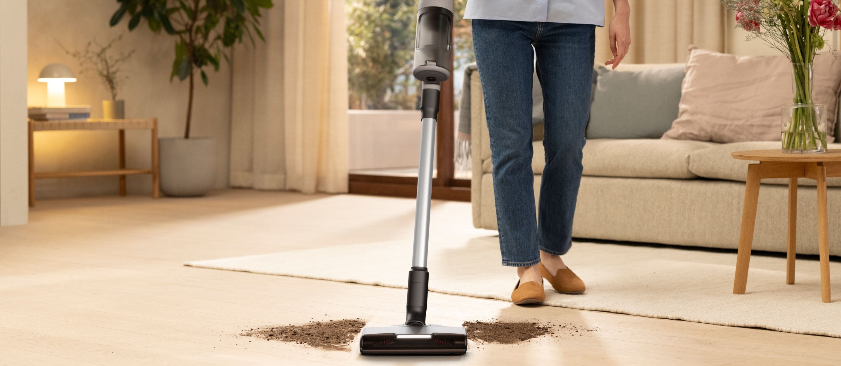 Woman vacuuming floor in living room.