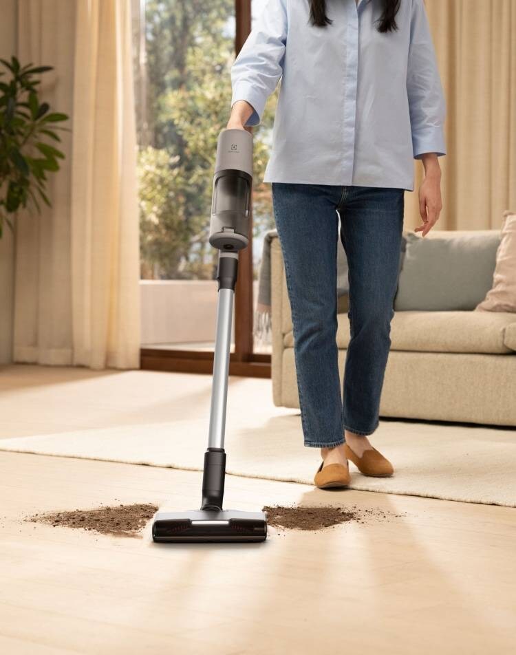 Woman vacuuming floor in living room.