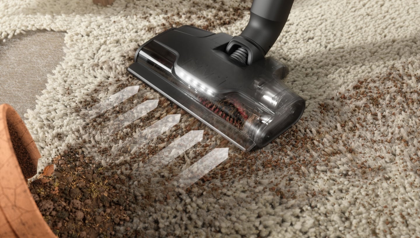 Close up of a vacuum nozzle on a carpet.
