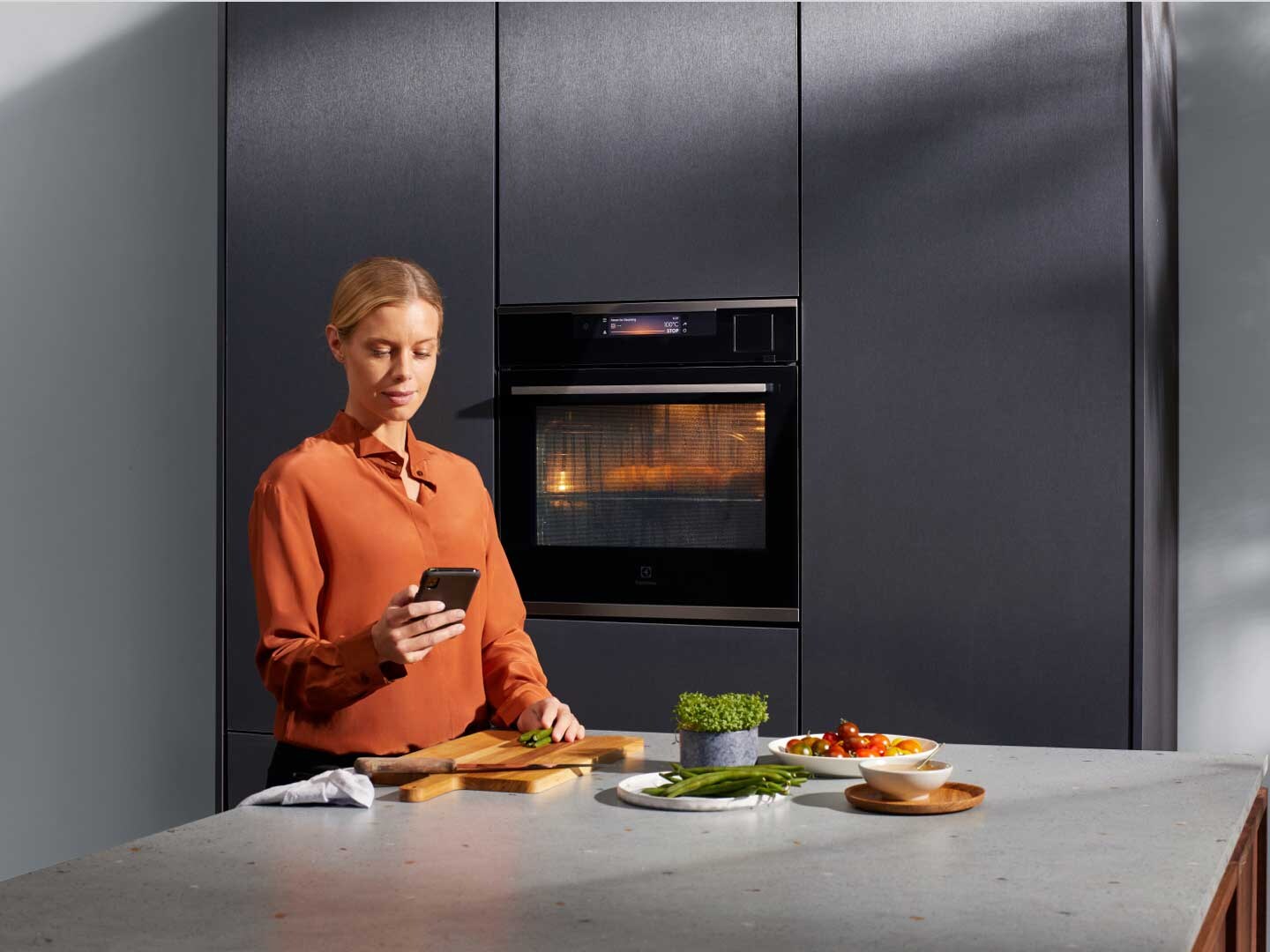 Woman with phone in modern kitchen